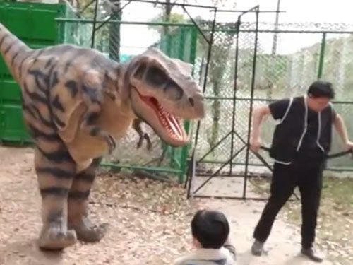 Trex Costume Walks Up to Tourist